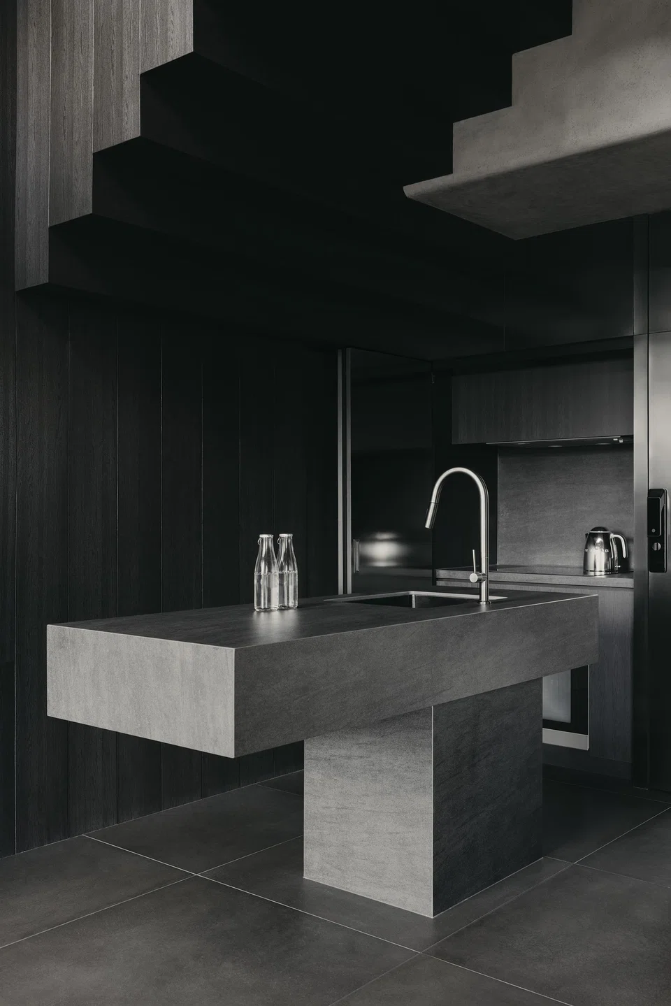The kitchen island, designed like a piece of furniture, has a cantilevering top that balances its robust proportions. 