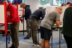 Voters mark their ballots during early voting at a polling location in Arlington, Virginia. Faced with two radically different candidates and visions for the country’s future, voters are girding themselves for the results – and fear of the possible unrest that could follow.