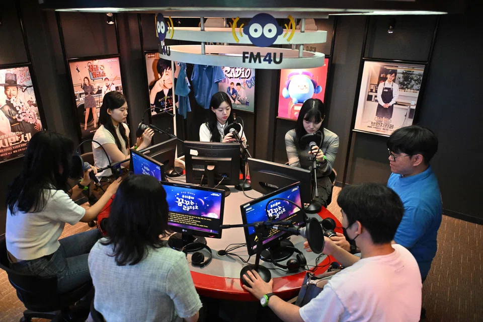 Visitors role-playing as radio DJs in a mock radio studio during an adult-only event at KidZania, a children's job experience theme park in Seoul, South Korea, June 28, 2024.