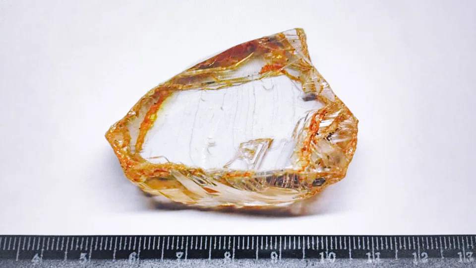 The stone found by Alrosa is of non-standard shape and bordered by a yellow-brown halo. 