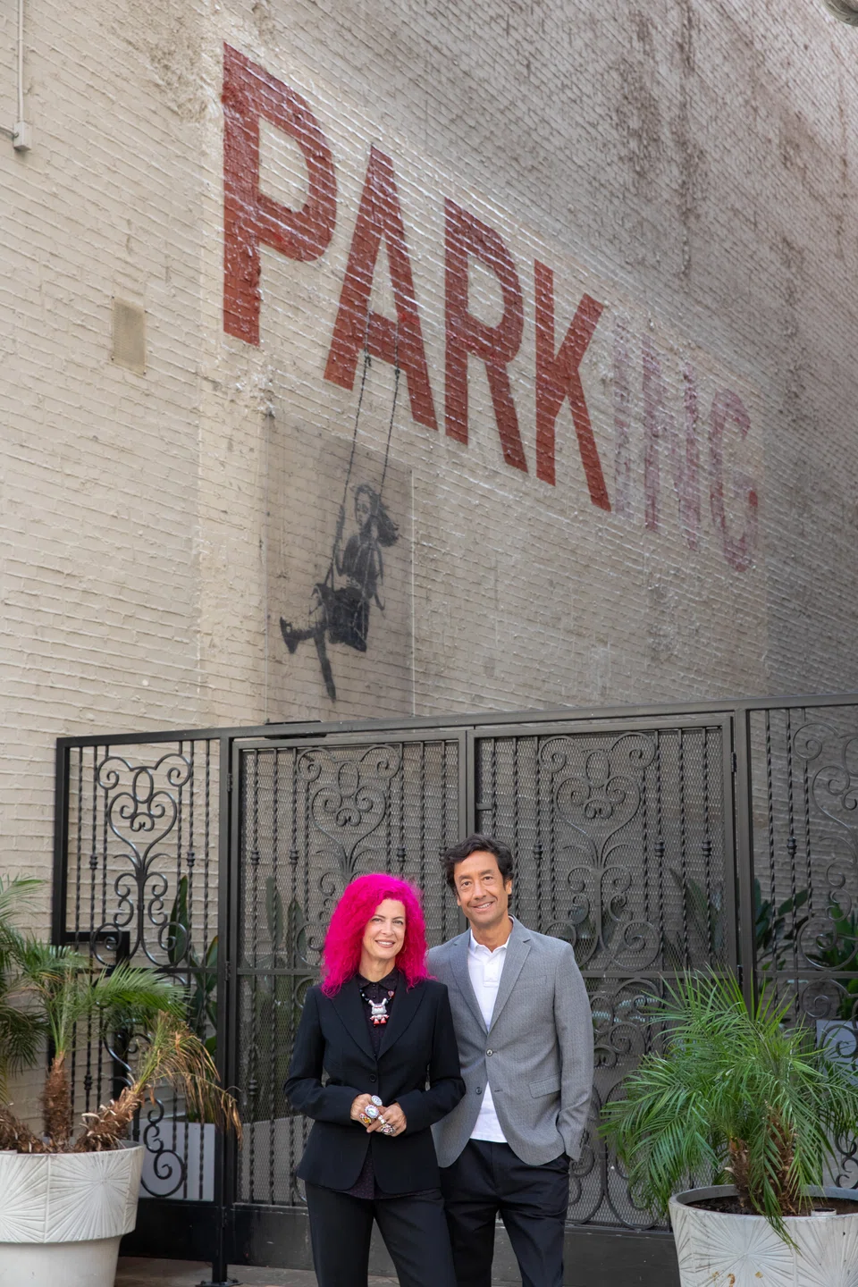 Tarina Tarantino and Alfonso Campos in front of the Bansky mural on their building in downtown Los Angeles in August 2022. Tarantino and Campos filed for Chapter 11 bankruptcy protection in April, and on Oct 6, as part of that filing, the building will be sold at auction. 