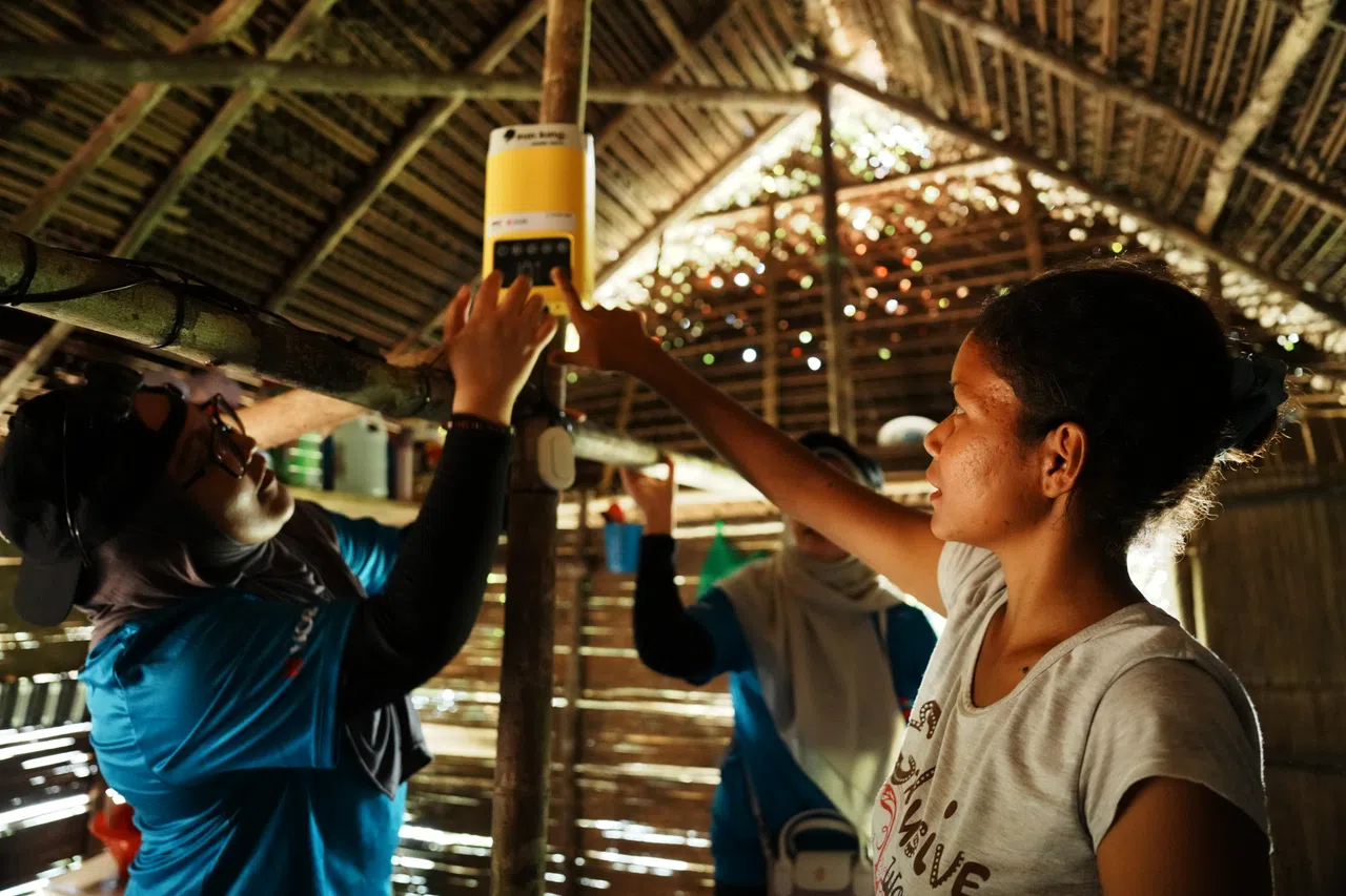 The volunteers installing the light and battery packs in the villagers’ homes.