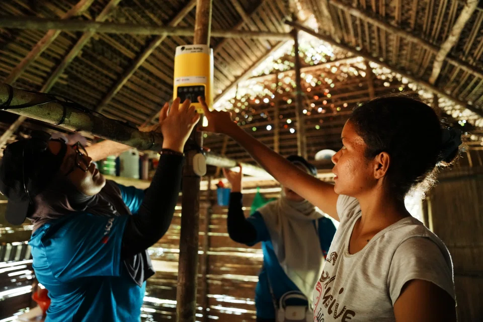 The volunteers installing the light and battery packs in the villagers’ homes.