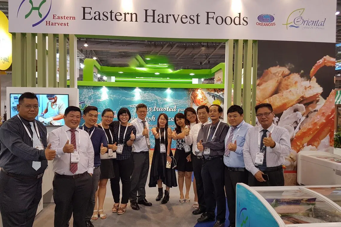 Eastern Harvest Foods founder and managing director Derek Cheng (sixth from left) with staff members at an exhibition booth.