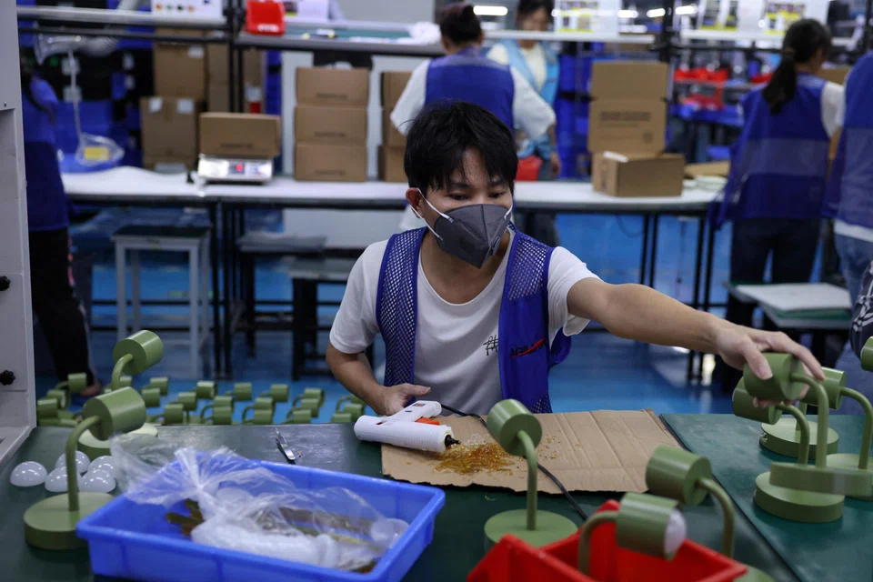 An employee works on a production line manufacturing electronic products at a Agilian Technology factory in Guangdong province on Mar 16. 