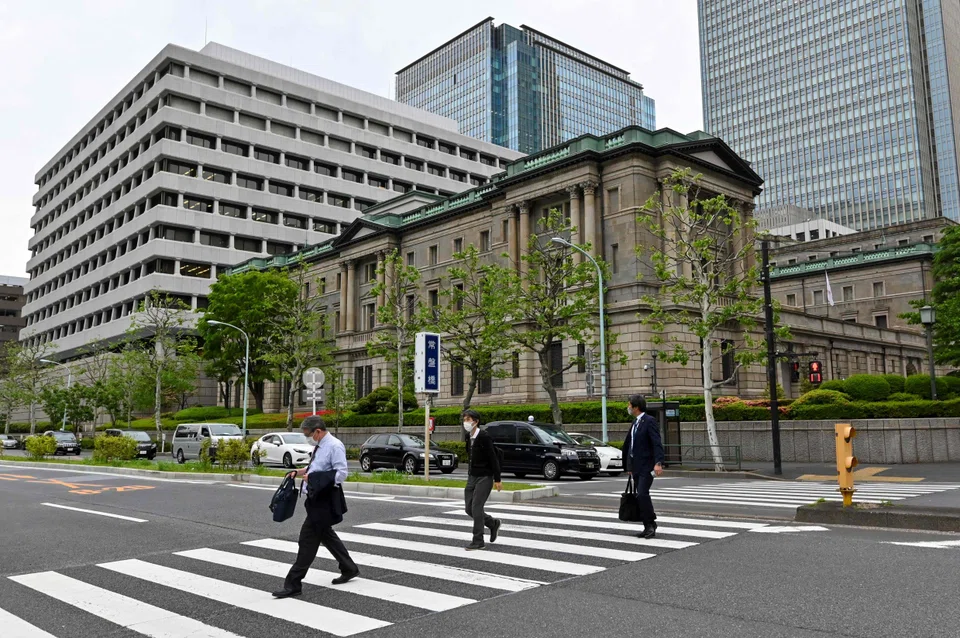 Pedestrians walk in front of the Bank of Japan head office building in Tokyo. Financial leaders from Japan, China and South Korea urged caution against heightening risks.