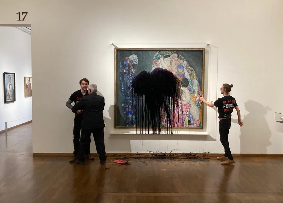 Florian Wagner, of the Last Generation group, is restrained while a fellow activist has glued himself to the painting Death and Life by Gustav Klimt after pouring black liquid over it, at the Leopold Museum in Vienna, Austria on Nov 15.