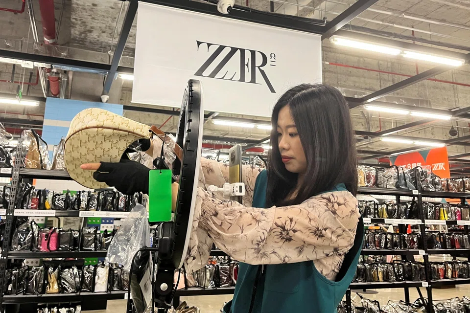A host promoting a bag during a livestreaming session at a warehouse of second-hand luxury e-commerce platform ZZER in Shanghai.
