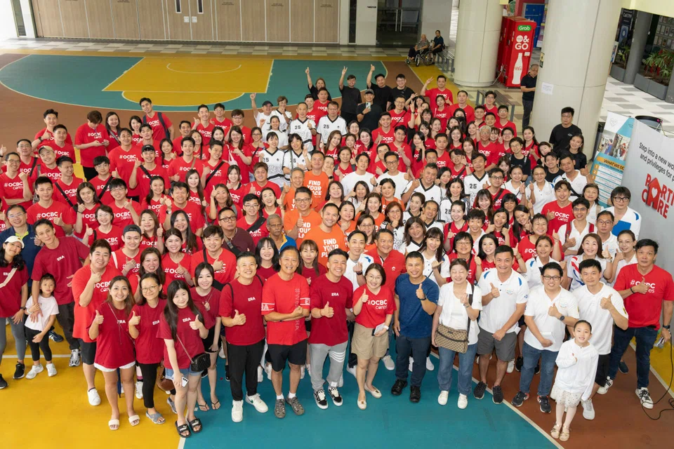 The collaborative effort is acknowledged by Minister for Education and Minister-in-Charge of Social Services Integration Desmond Lee (front row, in blue), who says that it is "wonderful to see this partnership of organisations".