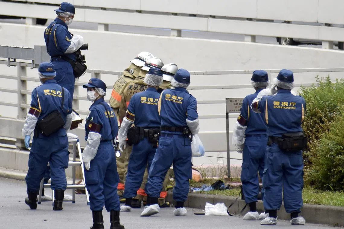 Police officers and firefighters investigate at the site where a man who was protesting a state funeral for former Japanese Prime Minister Shinzo Abe set himself on fire, near Prime Minster Fumio Kishida's official residence in Tokyo, Japan Sept 21, 2022.