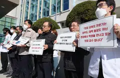 South Korean medical professors holding up signs protesting the government's plan to augment medical student admissions at Jeonbuk National University.  The health ministry this week reiterated that negotiations over the reform plans were out of the question.
