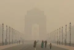 Women walk on a road in India's capital as the sky is enveloped with smog, in New Delhi, India, Nov 19, 2024. India, fifth in the smog rankings behind Chad, Bangladesh, Pakistan and the Democratic Republic of Congo, saw average PM2.5 fall 7 per cent on the year to 50.6 mg/cu m.