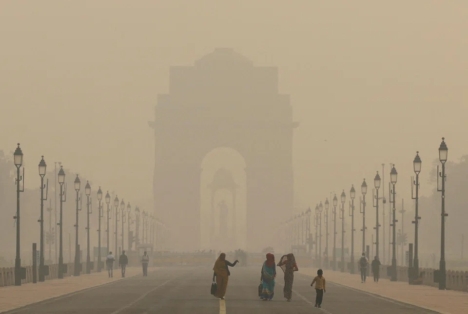 Women walk on a road in India's capital as the sky is enveloped with smog, in New Delhi, India, Nov 19, 2024. India, fifth in the smog rankings behind Chad, Bangladesh, Pakistan and the Democratic Republic of Congo, saw average PM2.5 fall 7 per cent on the year to 50.6 mg/cu m.