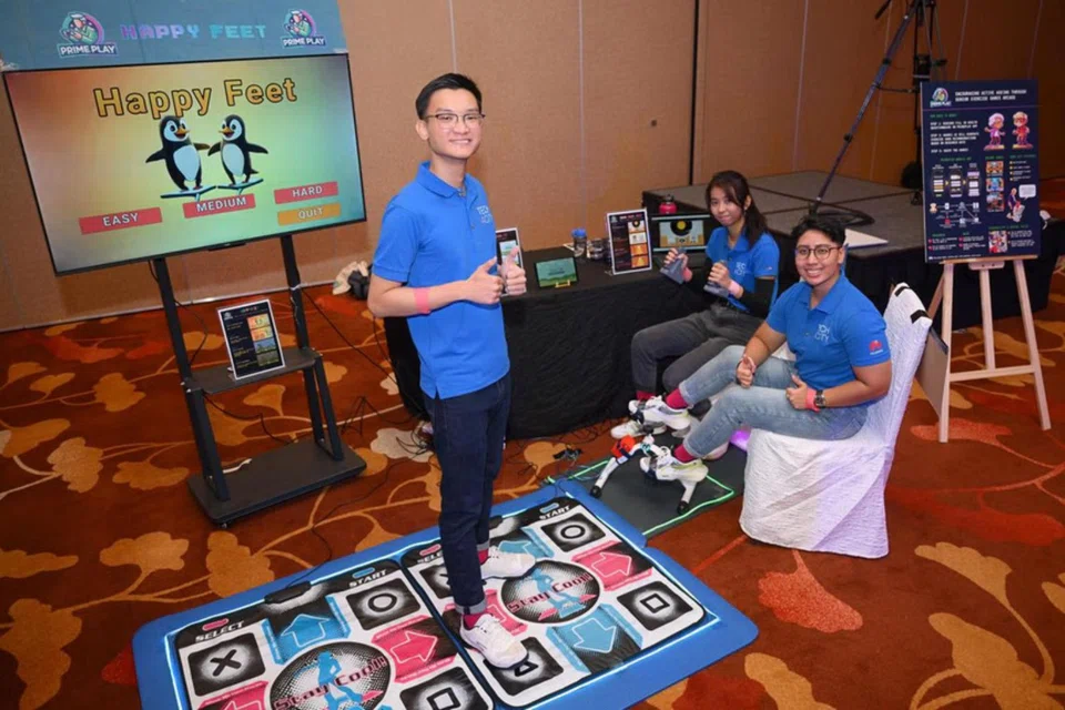 From left: Jonathon Leong, Fatin Sharafana, and Denise Caluza demonstrate their AI-powered rhythm game at Tech4City 2024.