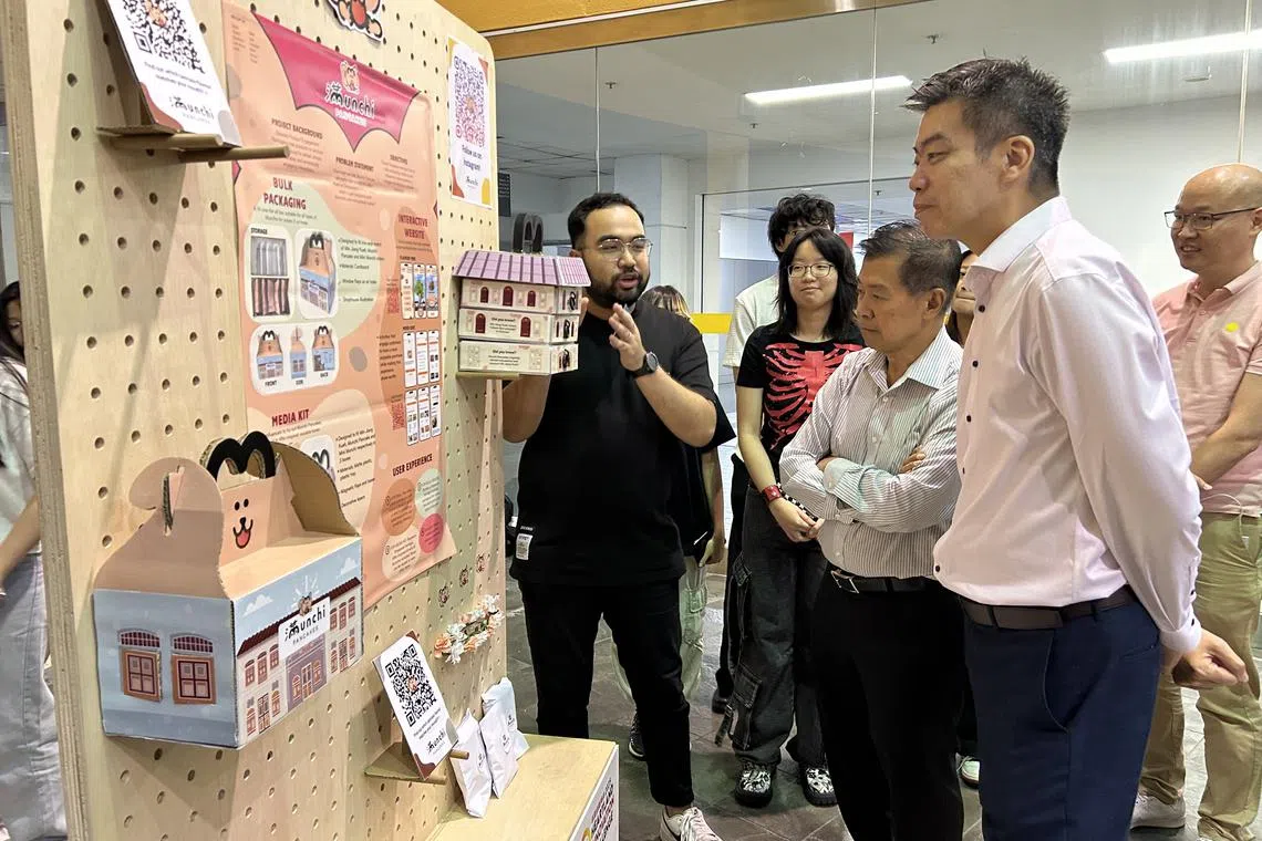 FMAS president Yeo Hiang Meng (third from left) and Nanyang Polytechnic principal and CEO Russell Chan (fourth from left) viewing the prototype business solutions of a heartland merchant.
