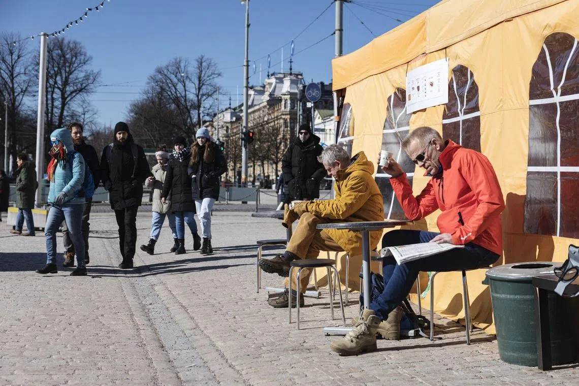 Customers outside a temporary cafe in Market Square in Helsinki, Finland, April 3, 2023. 