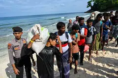 Rohingya refugees queue with their belongings at a beach in the Sabang island of Aceh province, Indonesia on Nov 22, 2023, as they are relocated by Indonesian authorities. 