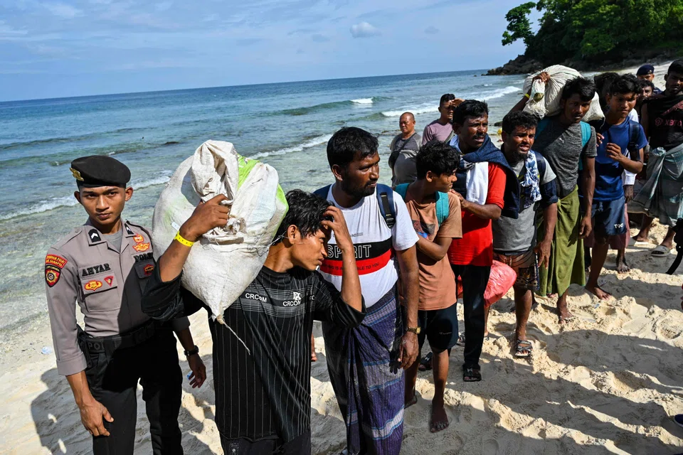 Rohingya refugees queue with their belongings at a beach in the Sabang island of Aceh province, Indonesia on Nov 22, 2023, as they are relocated by Indonesian authorities. 