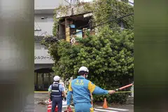 Police officers stand guard near a building damaged following an earthquake in Miyazaki, southwestern Japan.