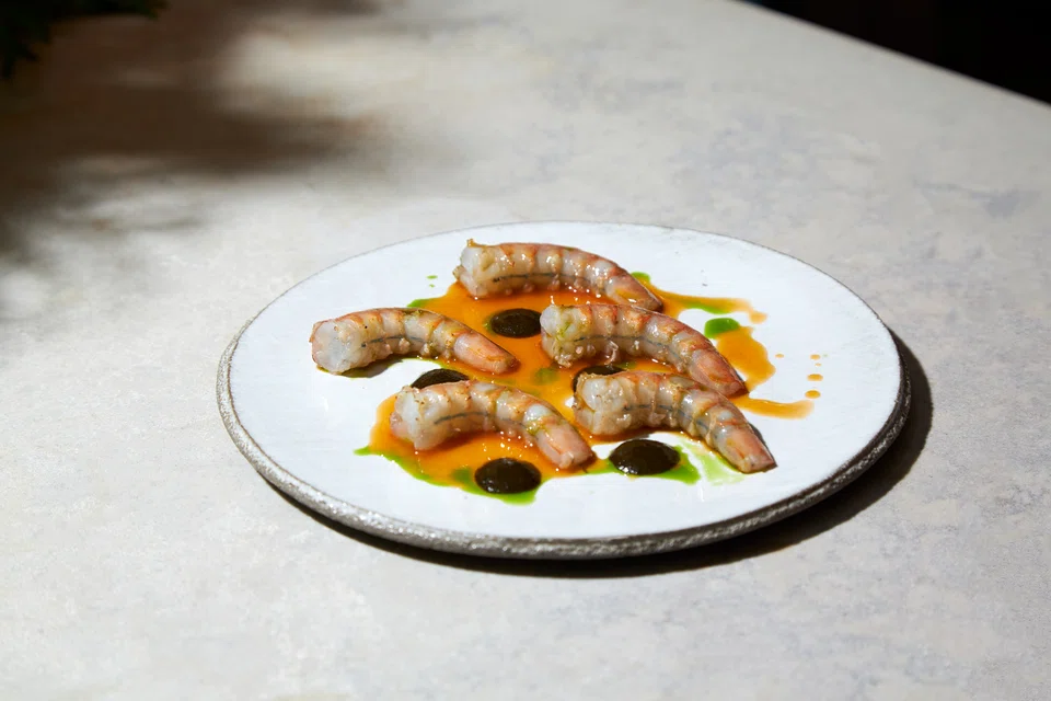 Firm and fleshy raw prawns drizzled with herb oil along with dabs of wakame paste.