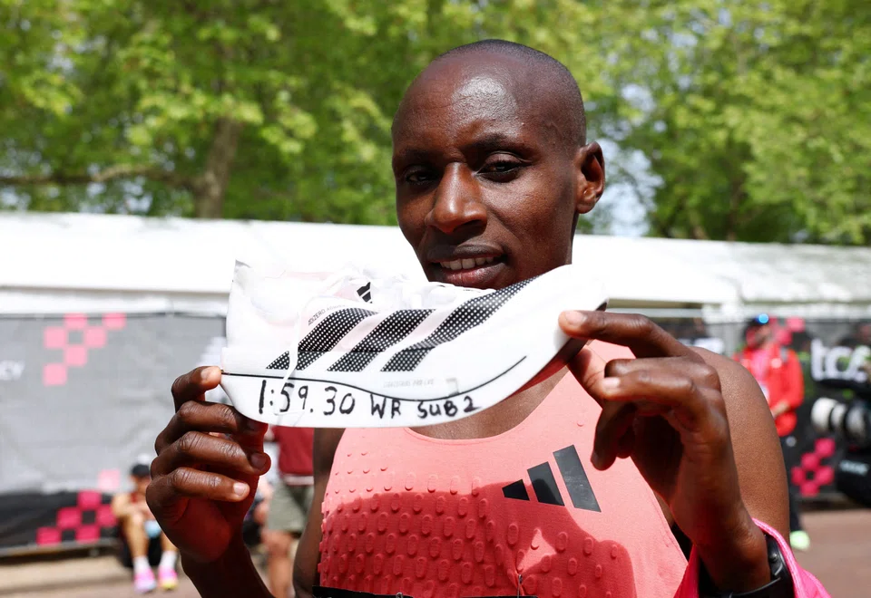 Kenya's Sabastian Sawe celebrates with an Adidas Adizero Adios Pro Evo 3 shoe after winning the men's elite race and setting a new world record.