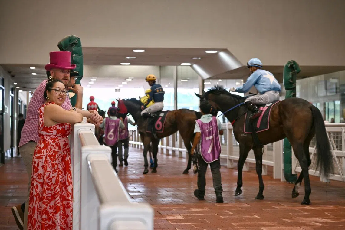 Punters catching a glimpse of the race horses at the Singapore Derby 2024 race meeting at Singapore Turf Club on Sunday (Jul 21). 
