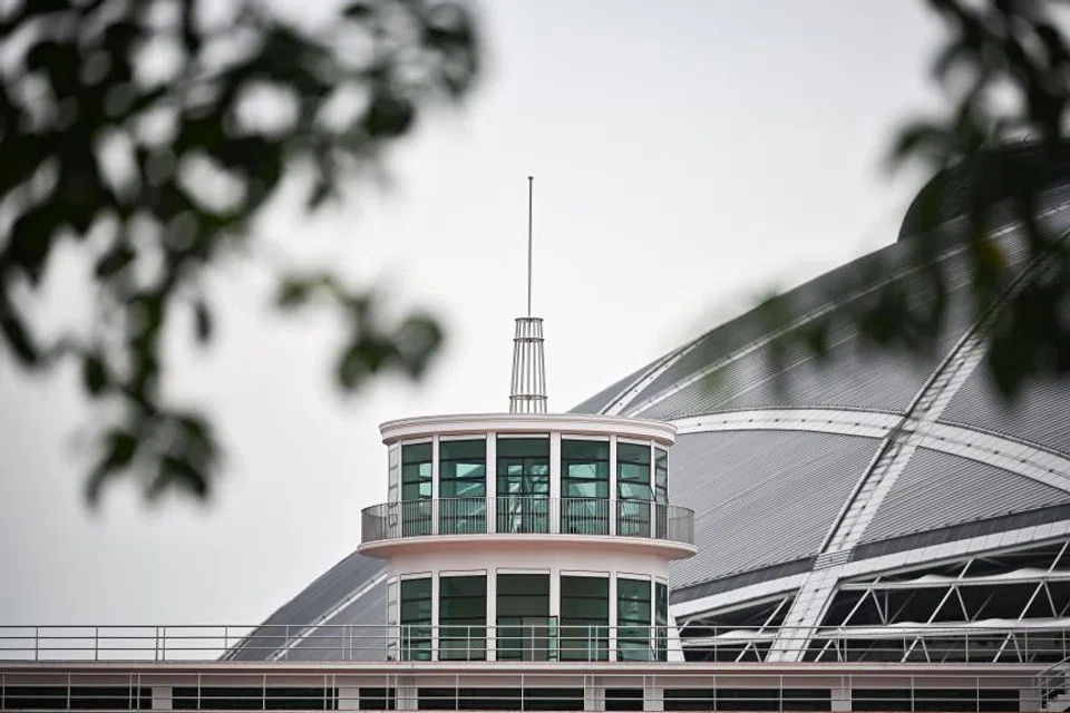 The top of the old airport's terminal building, with the National Stadium's domed roof seen in the background. The site that the Singapore Sports Hub occupies was once the airport's airfield. 