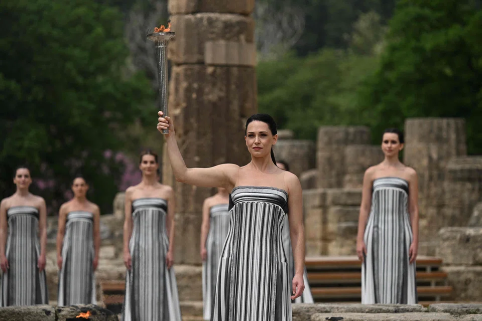 Greek actress Mary Mina, playing the role of the High Priestess, holds the torch after lighting it during the Olympic torch lighting ceremony for the Paris 2024 Olympics Games at the Ancient Olympia archeological site.