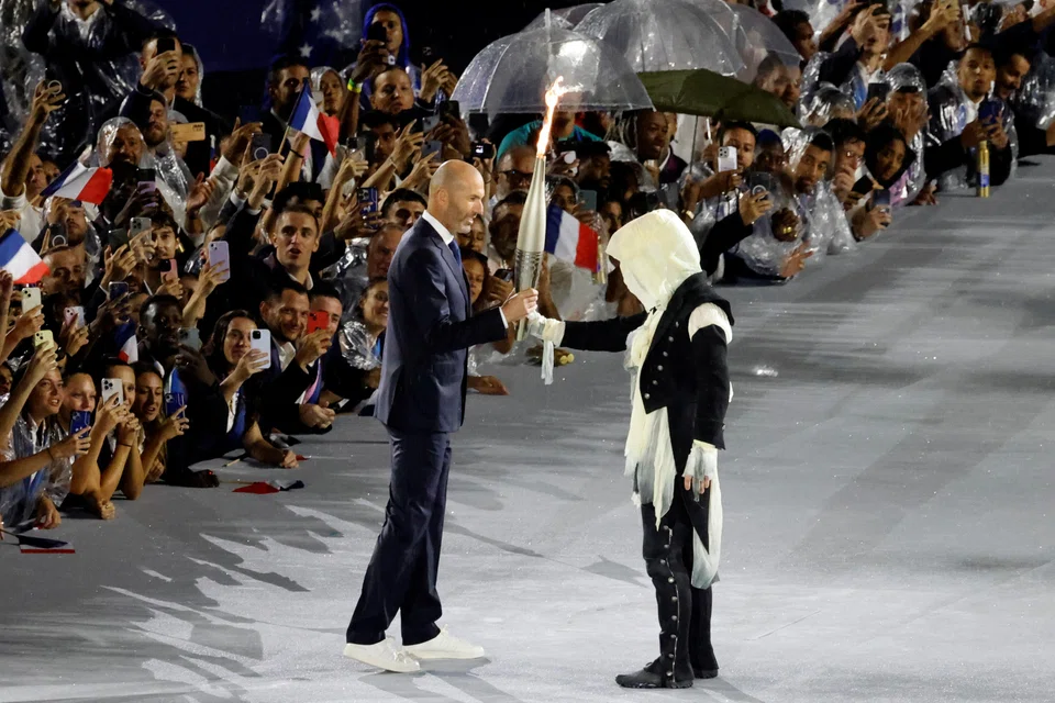 French former football player Zinedine Zidane holds the Olympic flame at the Trocadero during the opening ceremony of the Paris 2024 Olympic Games, Paris, France, July 26, 2024.