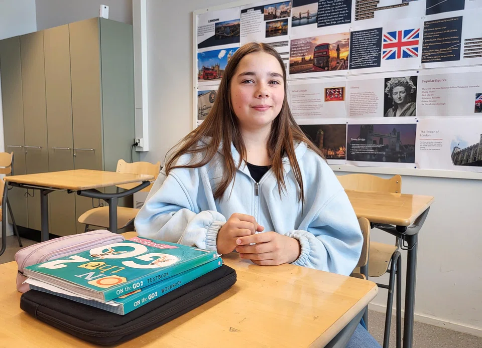 Eight-grader Inka Warro, 14, sits near her English language books at Pohjolanrinne middle school in Finland.