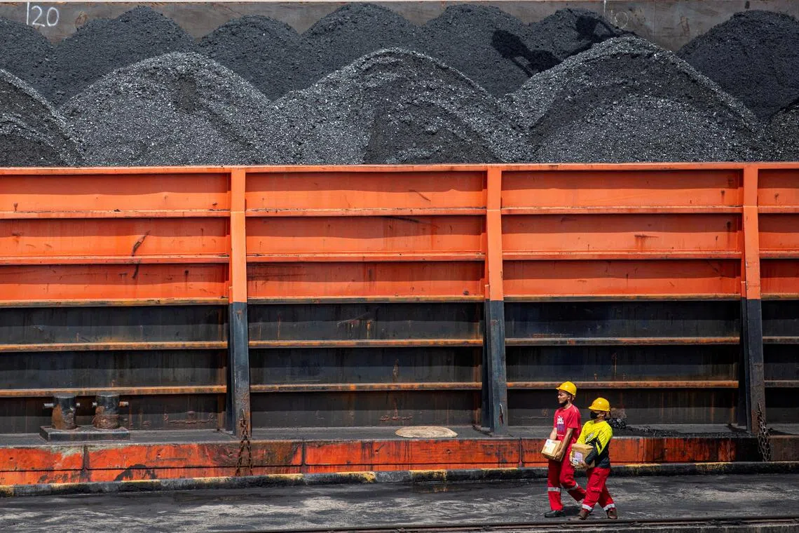 FILE PHOTO: Workers walk near a tugboat carrying coal barges at a port in Palembang, South Sumatra province, Indonesia, January 4, 2022, in this photo taken by Antara Foto. Antara Foto/Nova Wahyudi/ via REUTERS  ATTENTION EDITORS - THIS IMAGE HAS BEEN SUPPLIED BY A THIRD PARTY. MANDATORY CREDIT. INDONESIA OUT. NO COMMERCIAL OR EDITORIAL SALES IN INDONESIA.//File Photo