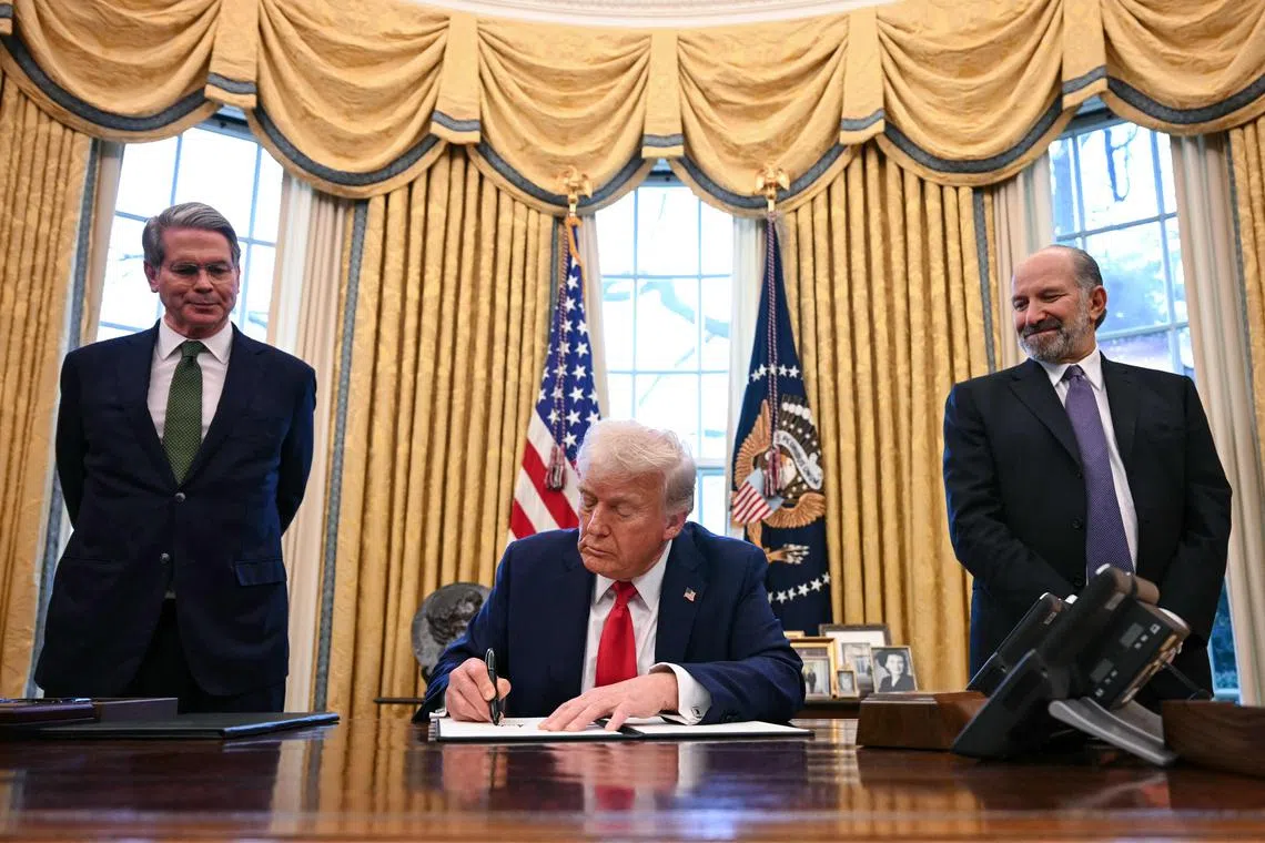 US President Donald Trump, alongside Secretary of Treasury Scott Bessent (L) and Secretary of Commerce nominee Howard Lutnick (R), signs an executive order to create a US sovereign wealth fund, in the Oval Office of the White House on February 3, 2025, in Washington, DC. (Photo by Jim WATSON / AFP)