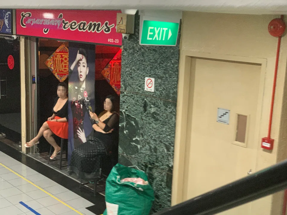 Two women sitting outside a beauty salon in Orchard Towers at lunchtime on Aug 25, 2022. 