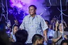 Defence Minister Prabowo Subianto celebrates on stage as unofficial vote counts show that he is poised to become Indonesia's next president.