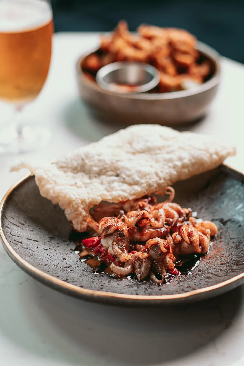 Baby squid-like octopus shines in a smoky braised red peppers.