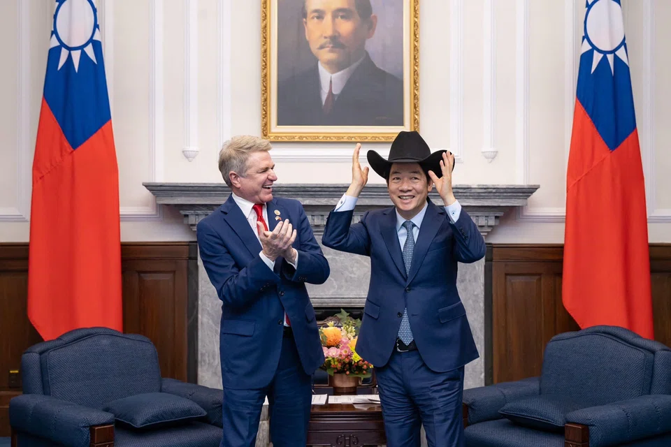 Taiwan's President Lai Ching-te (R) putting on a hat received from US Representative Michael McCaul during a meeting at the Presidential Office in Taipei. 
