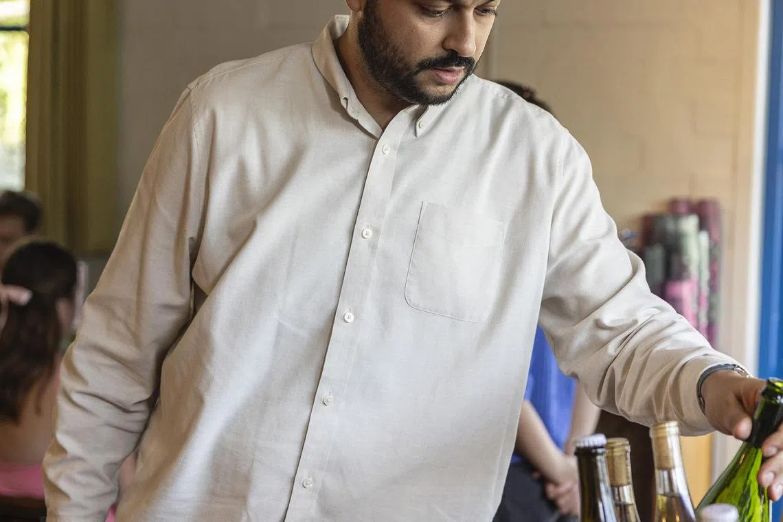 Arjav Ezekiel prepares wine at BirdieÕs, his restaurant in Austin, Texas on Aug. 6, 2024. Ezekiel rose through the restaurant ranks, becoming a sommelier and opening BirdieÕs but few knew of his past as an undocumented immigrant. (Jessica Attie/The New York Times)