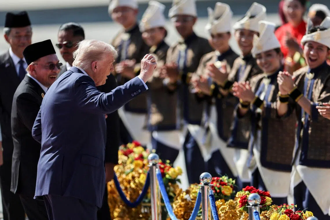 TOPSHOT - US President Donald Trump (C) joins performers for a dance during the welcome ceremony next to Malaysia's Prime Minister Anwar Ibrahim (L) as he arrives on Air Force One at Kuala Lumpur International Airport in Kuala Lumpur on October 26, 2025. US President Donald Trump arrived in Malaysia on October 26 on the first leg of an Asian tour that will include high-stakes trade talks with Chinese counterpart Xi Jinping. (Photo by Hasnoor Hussain / POOL / AFP)