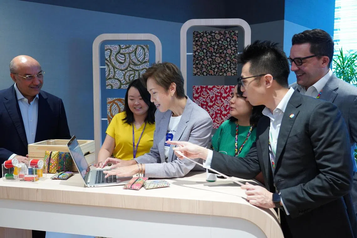 Minister for Communications and Information Josephine Teo (centre) at a demonstration by small business owners on the use of chatbot Bard at the launch of the AI Trailblazers initiative on July 24, 2023. 