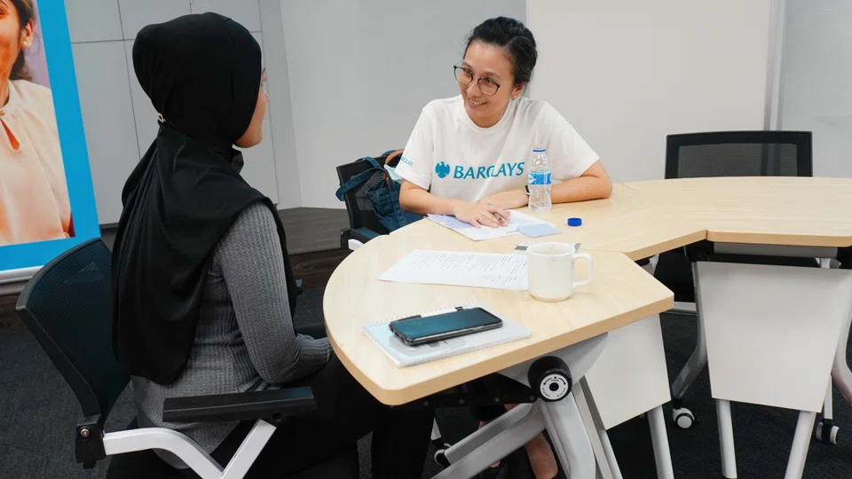 A volunteer from the Agape-Barclays partnership sharing resume editing and interview tips with a beneficiary.