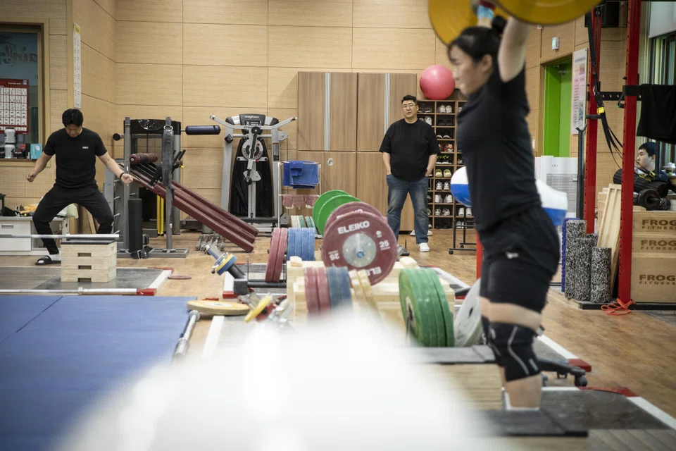 Jeon Sang-guen watches his daughter, Jeon Heesoo, training at the weightlifting club in her high school in Gyeongsan, South Korea. “I want her to be better than me,” he says.