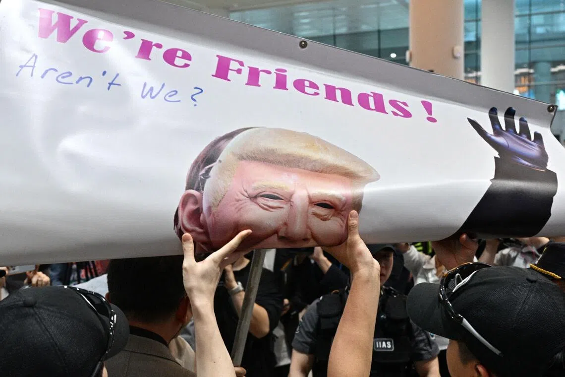 Police roll up a banner belonging to a protestor depicting US President Donald Trump at Incheon International Airport after a specially chartered Korean Air Boeing 747-81  bringing hundreds of South Korean workers back from Atlanta touched down, Incheon, South Korea, Sep 12, 2025.