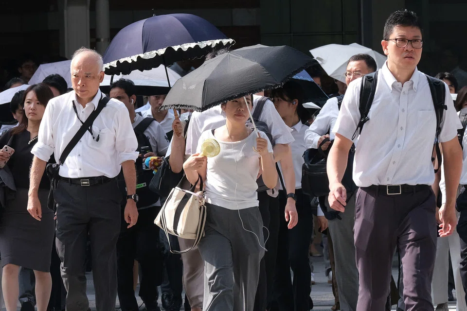 Commuters cross the street on their way to work on a hot, sunny morning in Tokyo on Aug 6, 2025. Heatwaves are becoming more intense and frequent worldwide because of human-caused climate change, scientists say, and Japan is no exception.