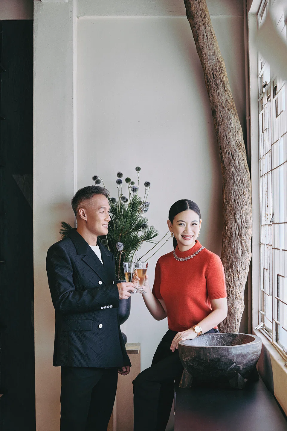 Tjin Lee wears a red knitted top, black wool trousers and Escale watch. John Lim wears a cream cotton T-shirt, black wool double-breasted suit and Escale watch. All by Louis Vuitton.