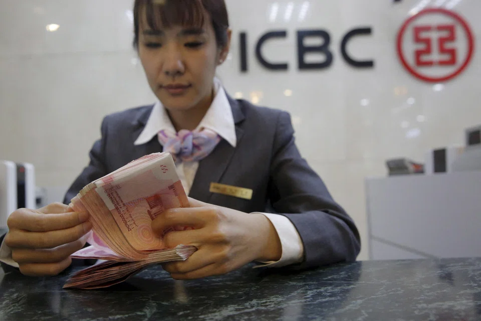 A clerk from ICBC bank counts Chinese banknotes in Beijing. China's six biggest state lenders saw growth in net profits slump to 6.7 per cent on average last year, about half the pace of 12.7 per cent in 2021.