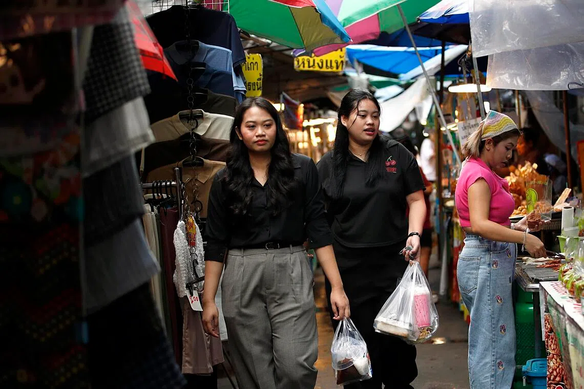 epa12949459 People walk among food stalls at a market in Bangkok, Thailand, 12 May 2026. The Bank of Thailand has revised its 2026 gross domestic product (GDP) growth forecast upward to 2.1 percent, from a previous projection of 1.5 percent, following the approval of a 400-billion-baht (12.3 billion USD) emergency loan decree to combat energy-driven living costs.  EPA/RUNGROJ YONGRIT