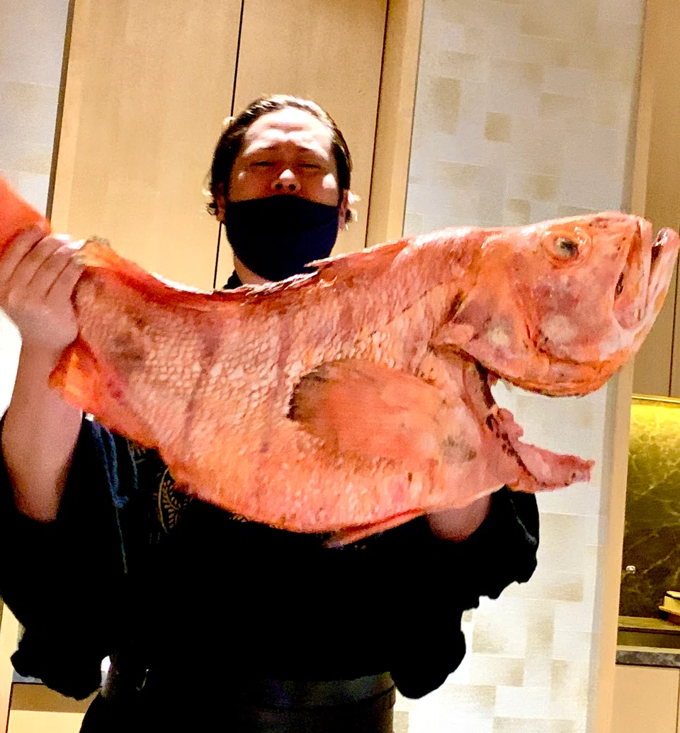 Chef Araki heaving under the weight of an 18kg rock fish.