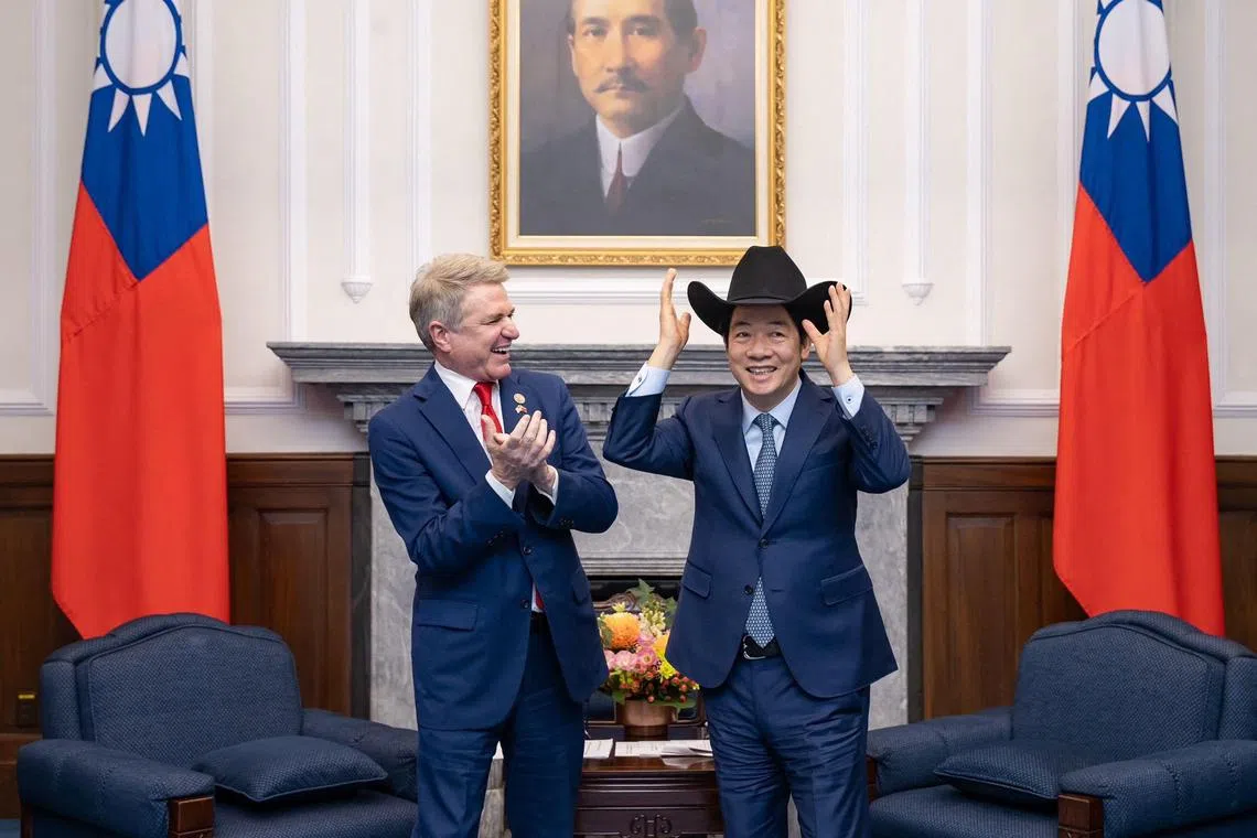Taiwan's President Lai Ching-te (R) putting on a hat received from US Representative Michael McCaul during a meeting at the Presidential Office in Taipei. 