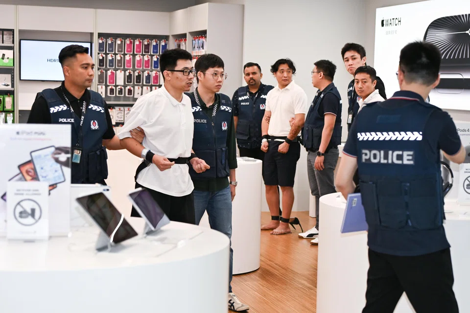 Accused Zhang Tianyu (second from left) walking past Li Xueqi (middle, in white top) and Xu Zhaochen (right, in white top) at the iStudio store in Bugis Junction on Nov 14. 