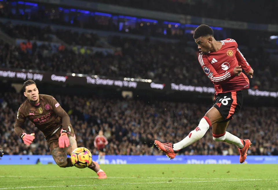 Manchester United's Amad Diallo (right) scores against Manchester City's goalkeeper Ederson to make it 2-1 in Manchester, Britain, Dec 15, 2024. 